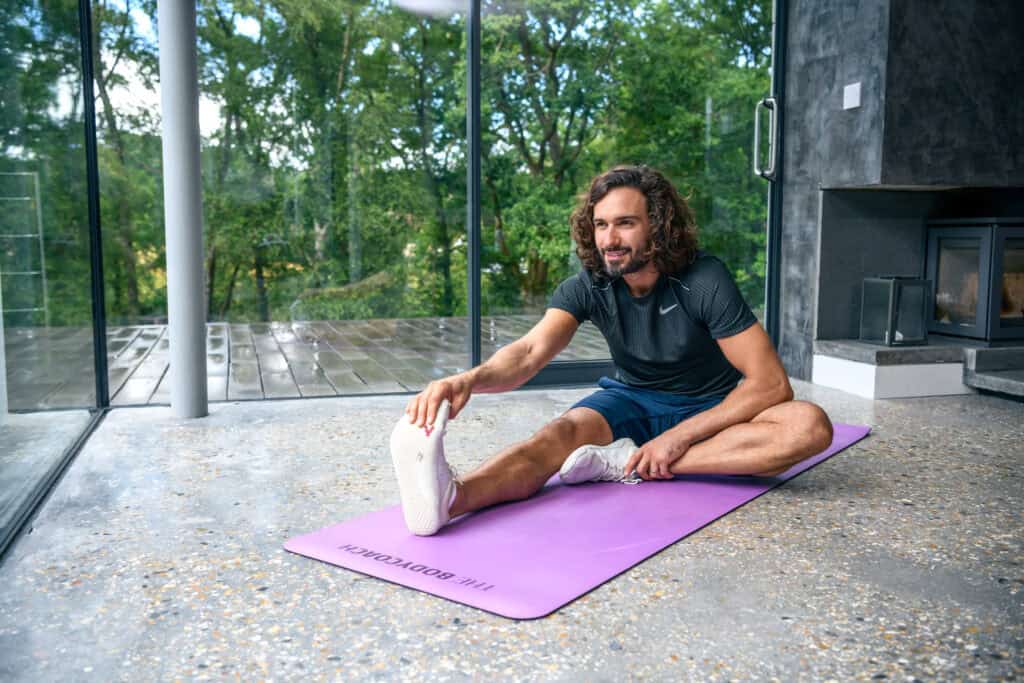 Person resting and stretching during a workout recovery day