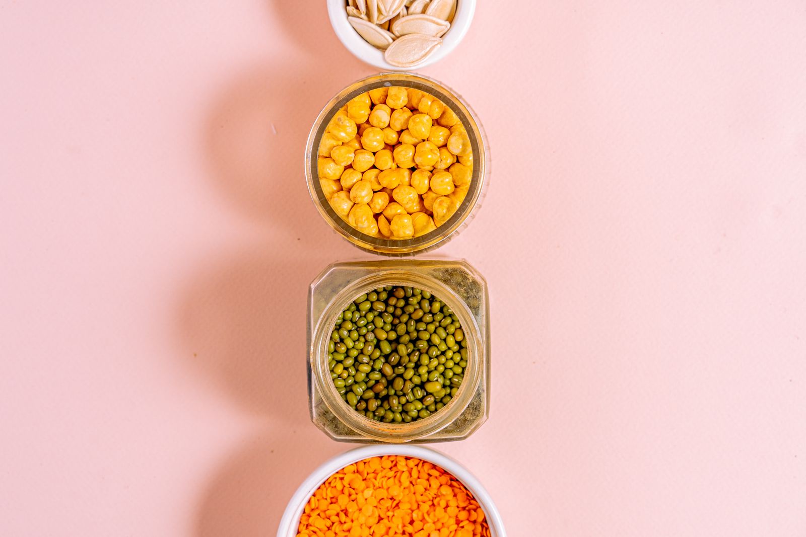Assorted legumes and seeds in jars, emphasizing healthy eating
