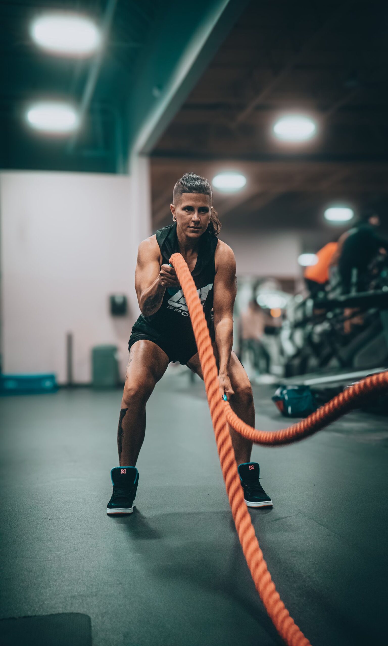 An athletic person performing an intense battle rope exercise