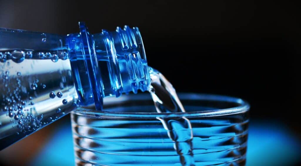 Water being poured into a glass to represent daily hydration habits