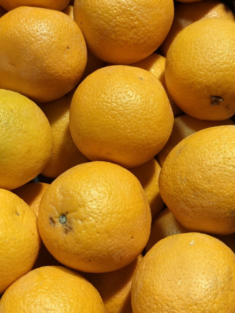 Vibrant oranges stacked together at a market