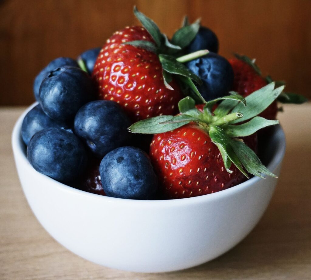 Fresh strawberries and blueberries in a ceramic bowl