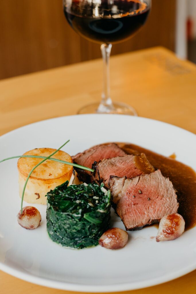 A meal with grilled meat and spinach, both iron-rich foods