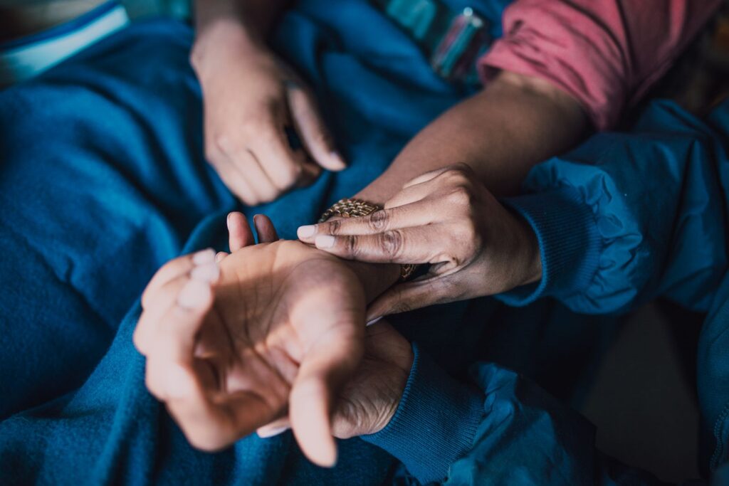 Hands checking a pulse on a patient’s wrist