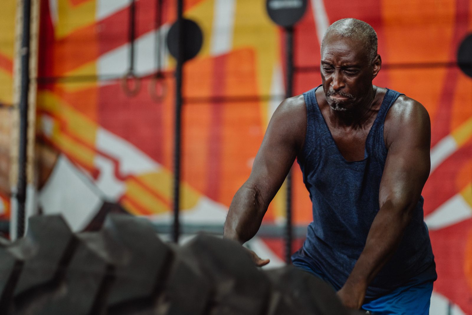 A muscular man sweating heavily during an intense tire-flipping workout