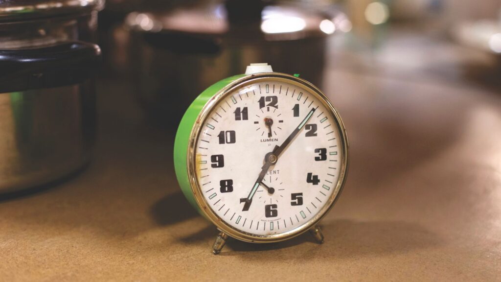 A clock next to kitchen pots, representing meal timing