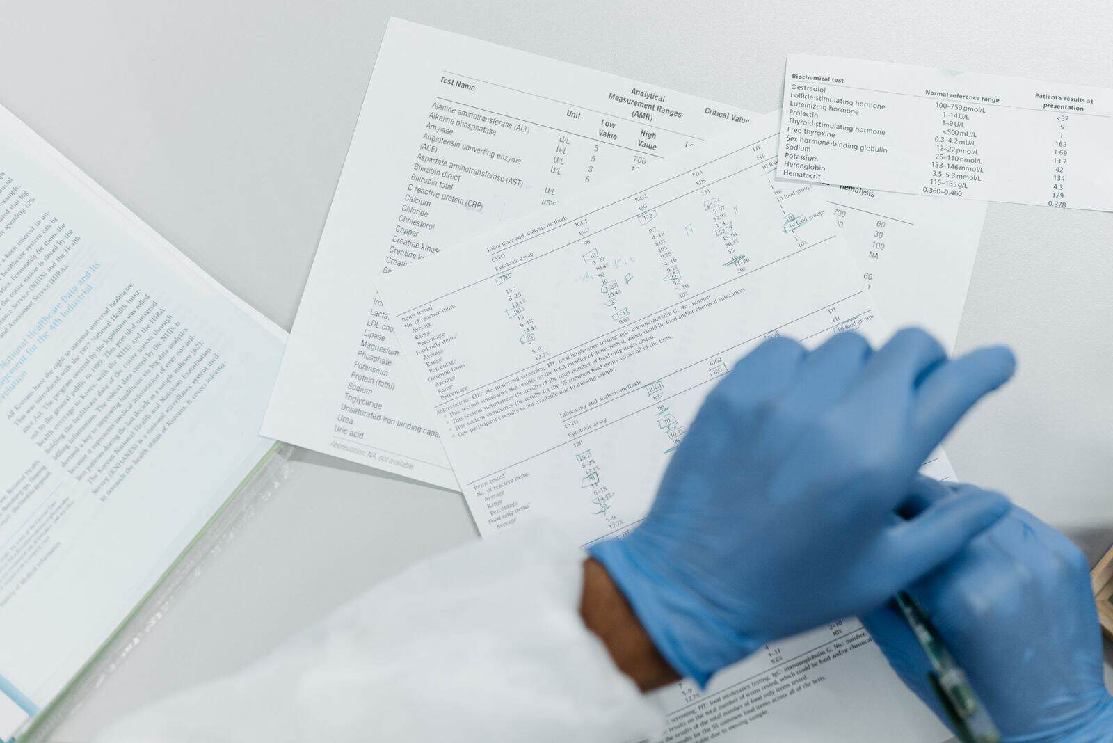 Gloved hands reviewing printed lab test results