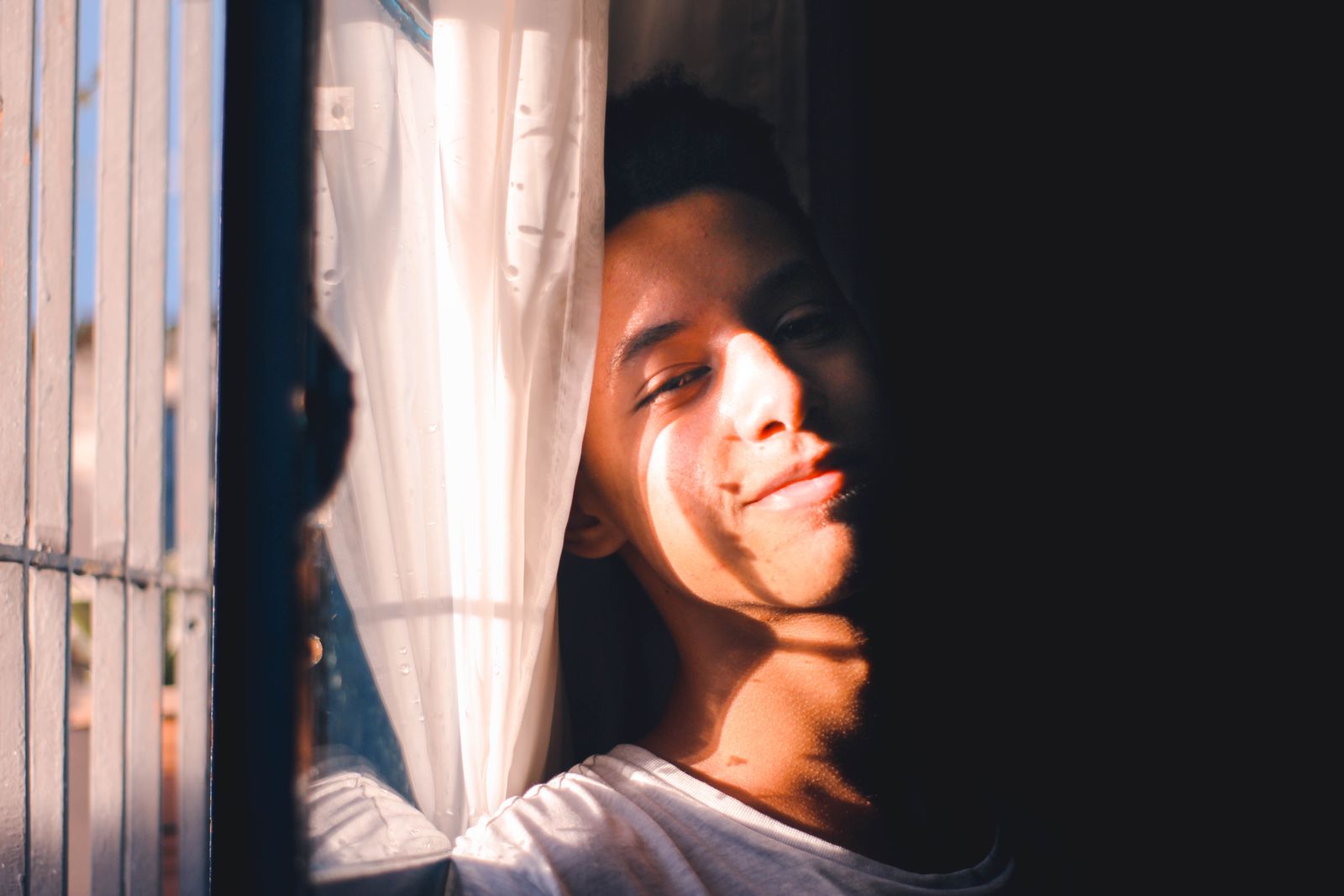 A man leaning near a window in bright morning sunlight