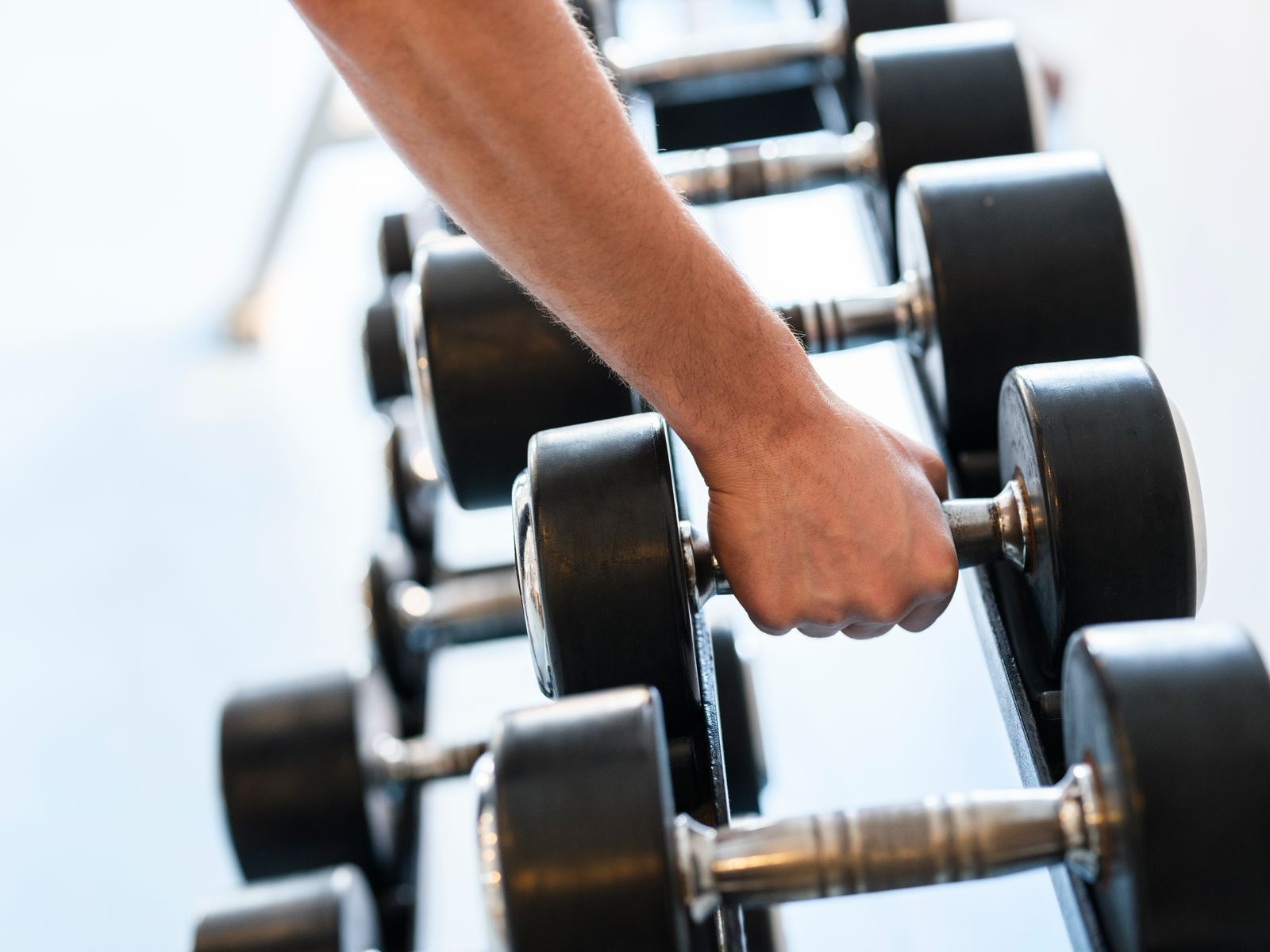 A man gripping a dumbbell in the gym