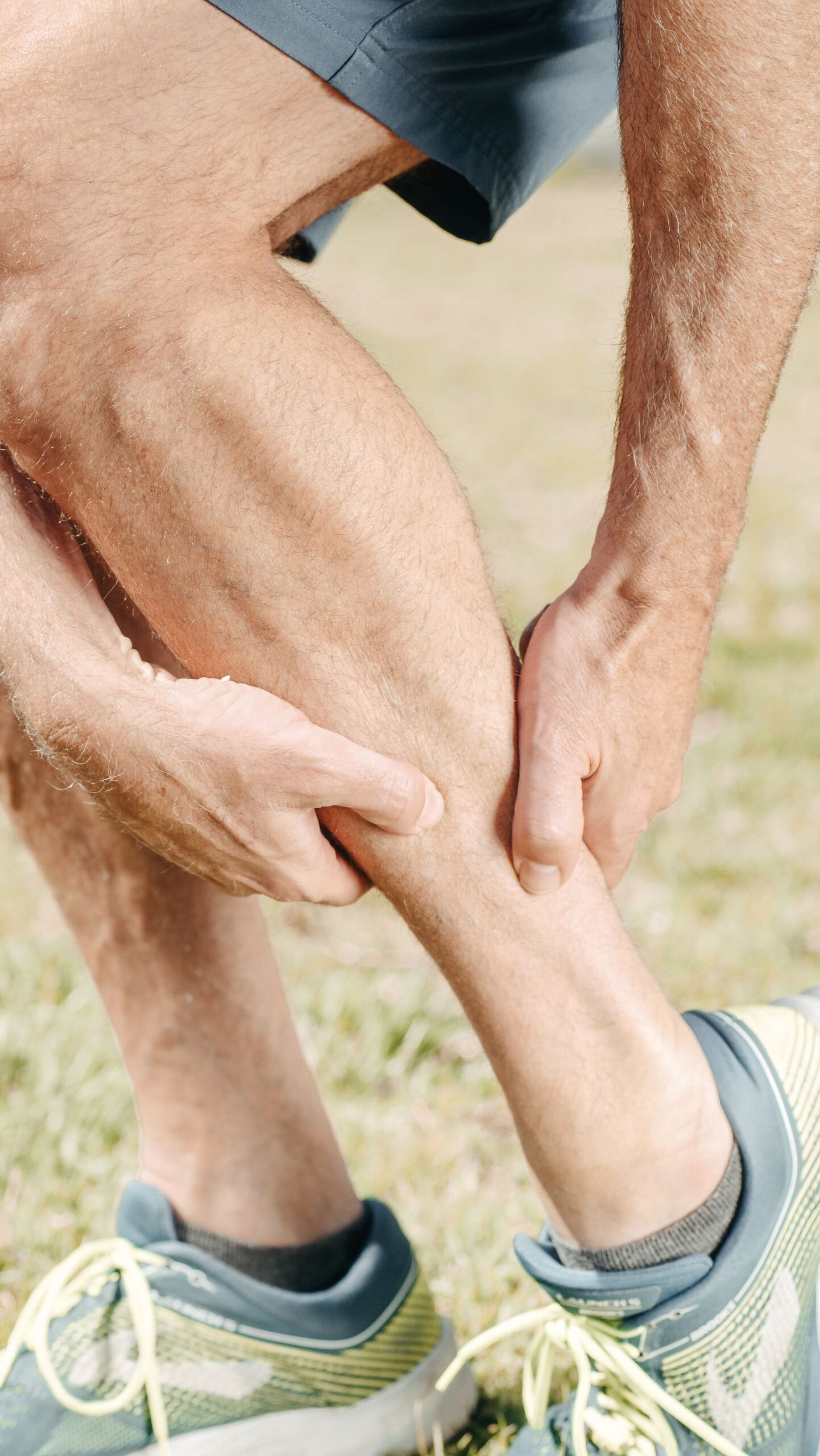 A man massaging his calf muscle after exercise