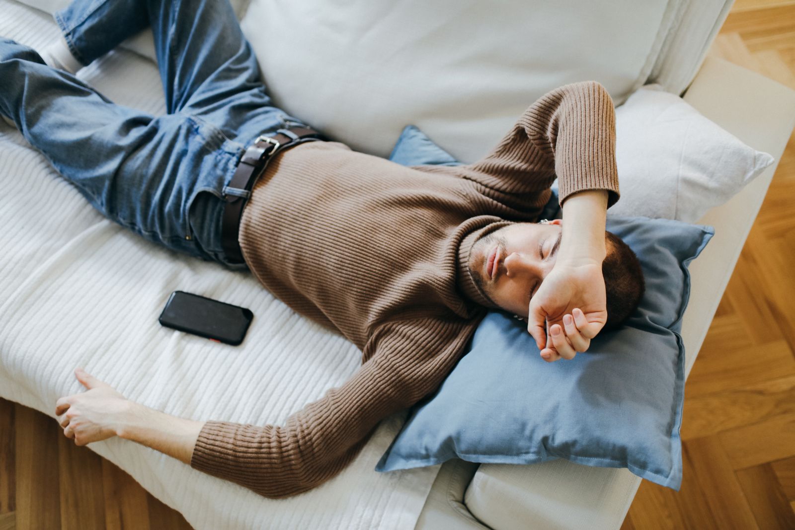 A man resting on a sofa at home during a short afternoon nap
