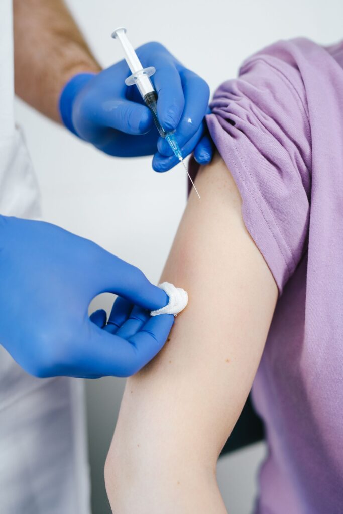 A medical professional giving a vaccine shot in a patient’s arm