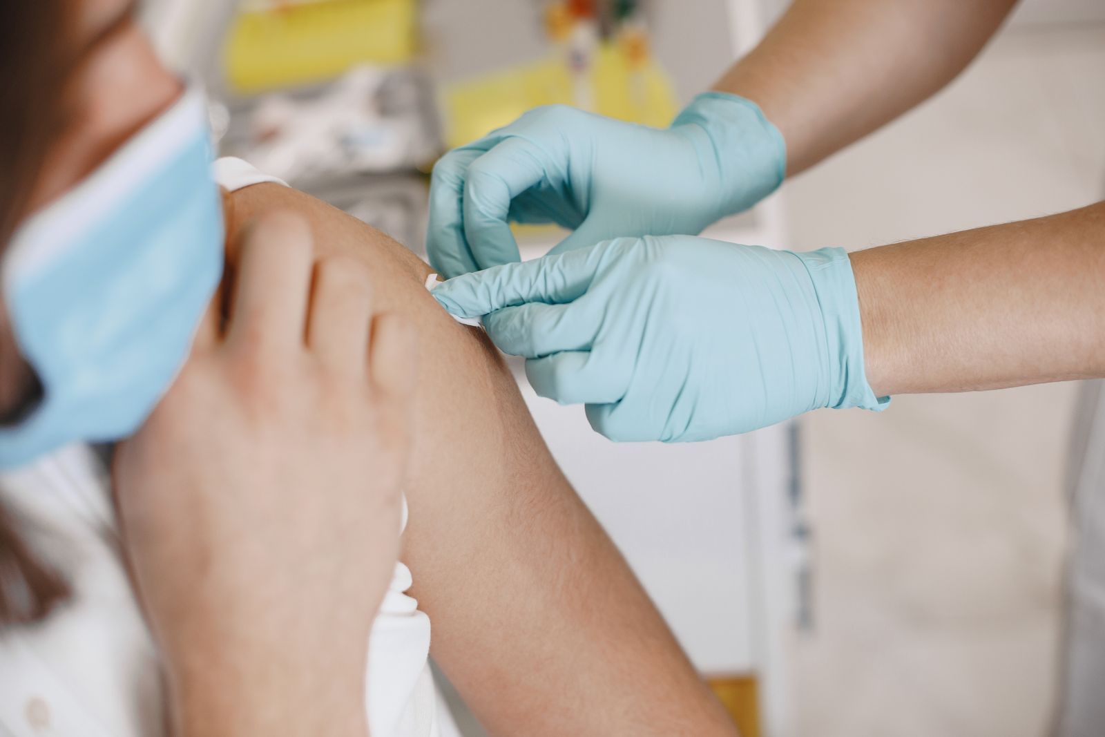 A nurse wearing gloves giving an injection to a patient