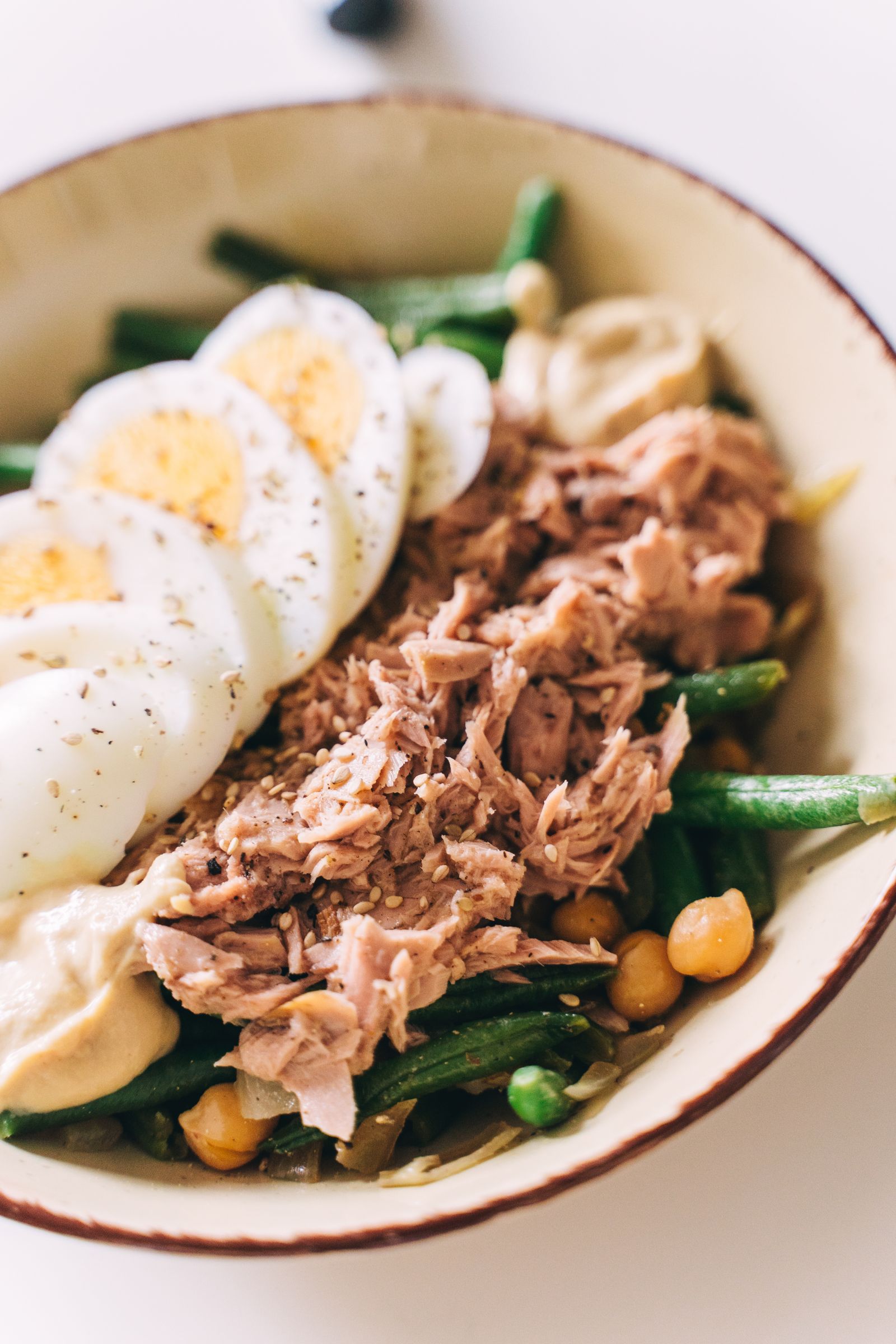 A salad with tuna, boiled eggs, green beans, and chickpeas as protein sources
