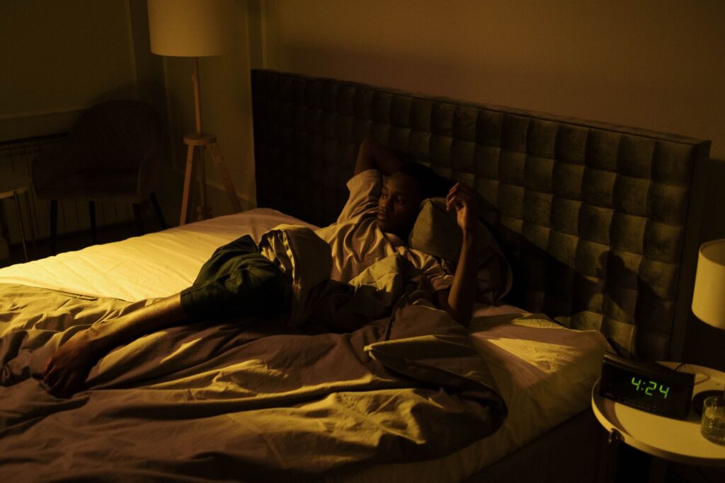 A man lying awake in bed at night, unable to sleep