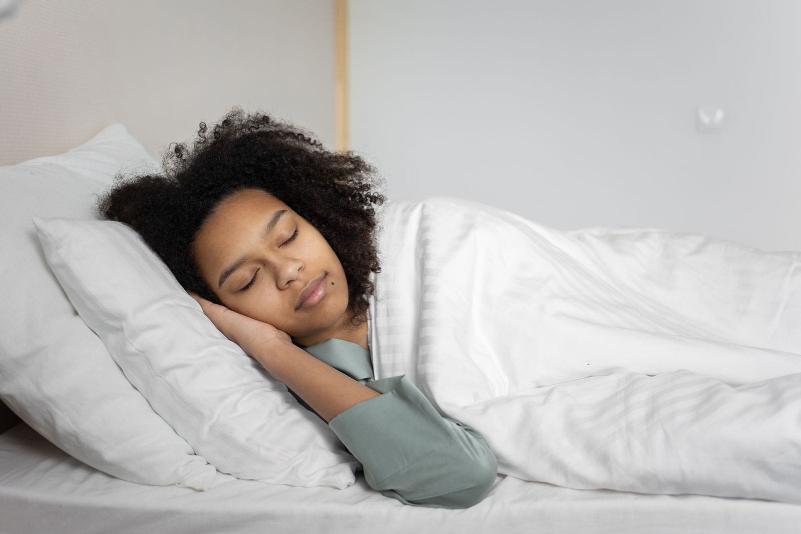 A woman peacefully sleeping in a cozy bedroom