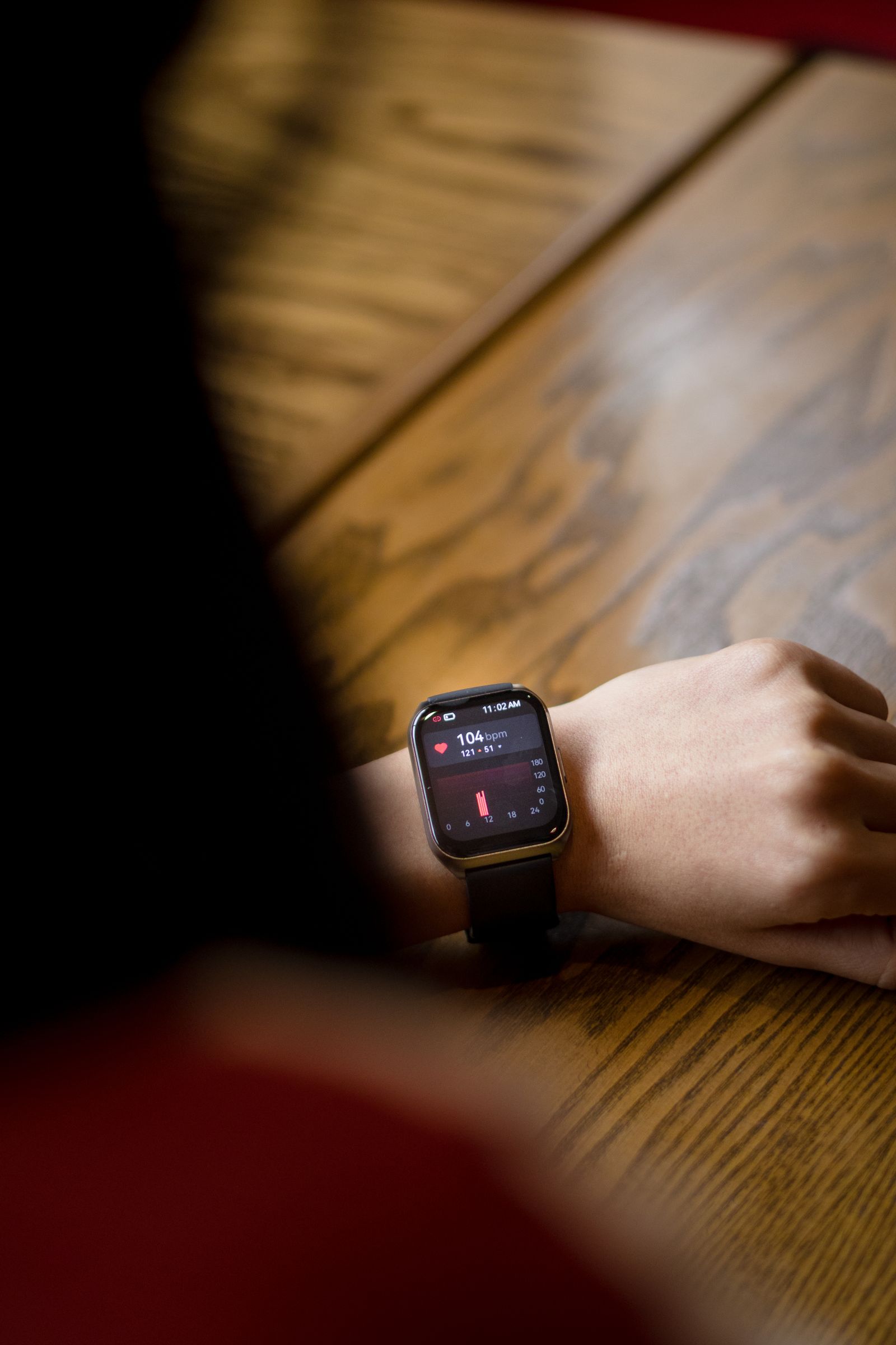 A smartwatch on a wrist showing a heart rate reading in beats per minute