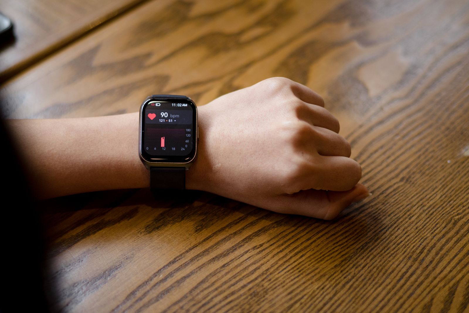 A smartwatch displaying a heart rate reading on a wrist