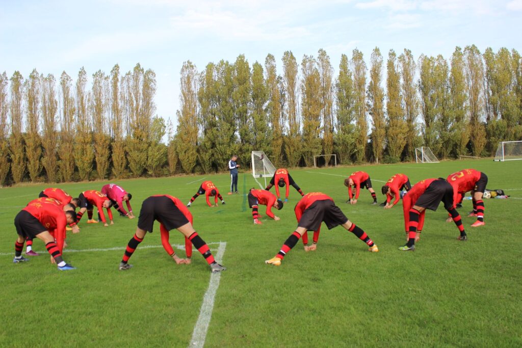 A soccer team warming up on the field before a game