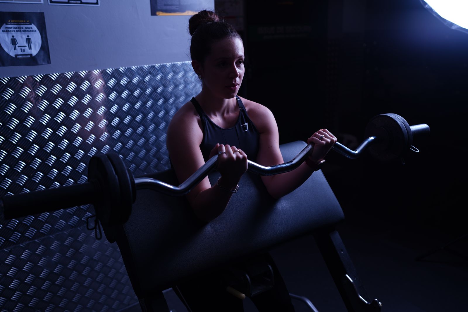 A woman weightlifting with a barbell in a gym