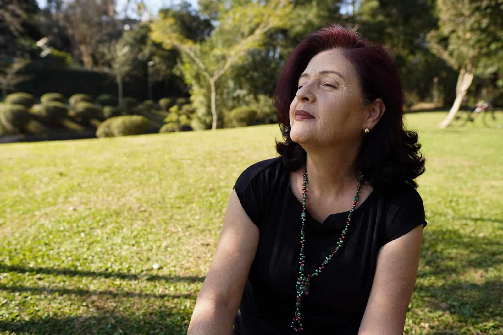 A woman relaxing outdoors in natural sunlight in a park