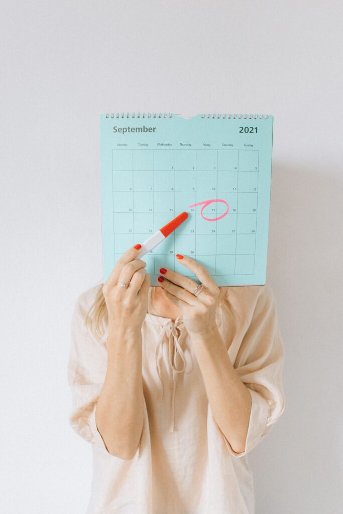 A woman holding a calendar with a date circled
