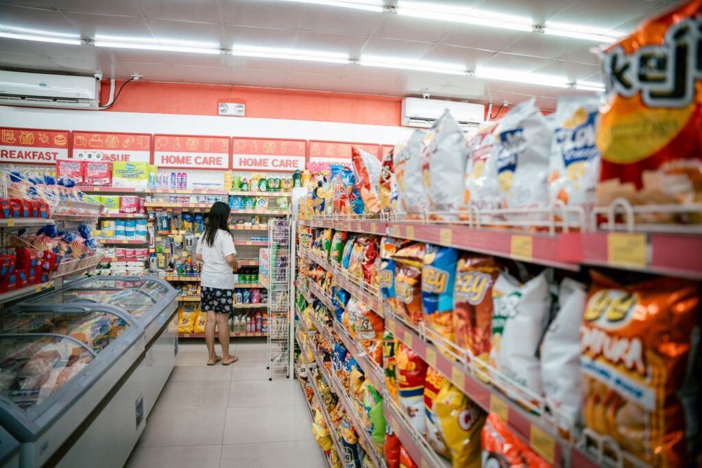 A woman browsing packaged food shelves in a grocery store