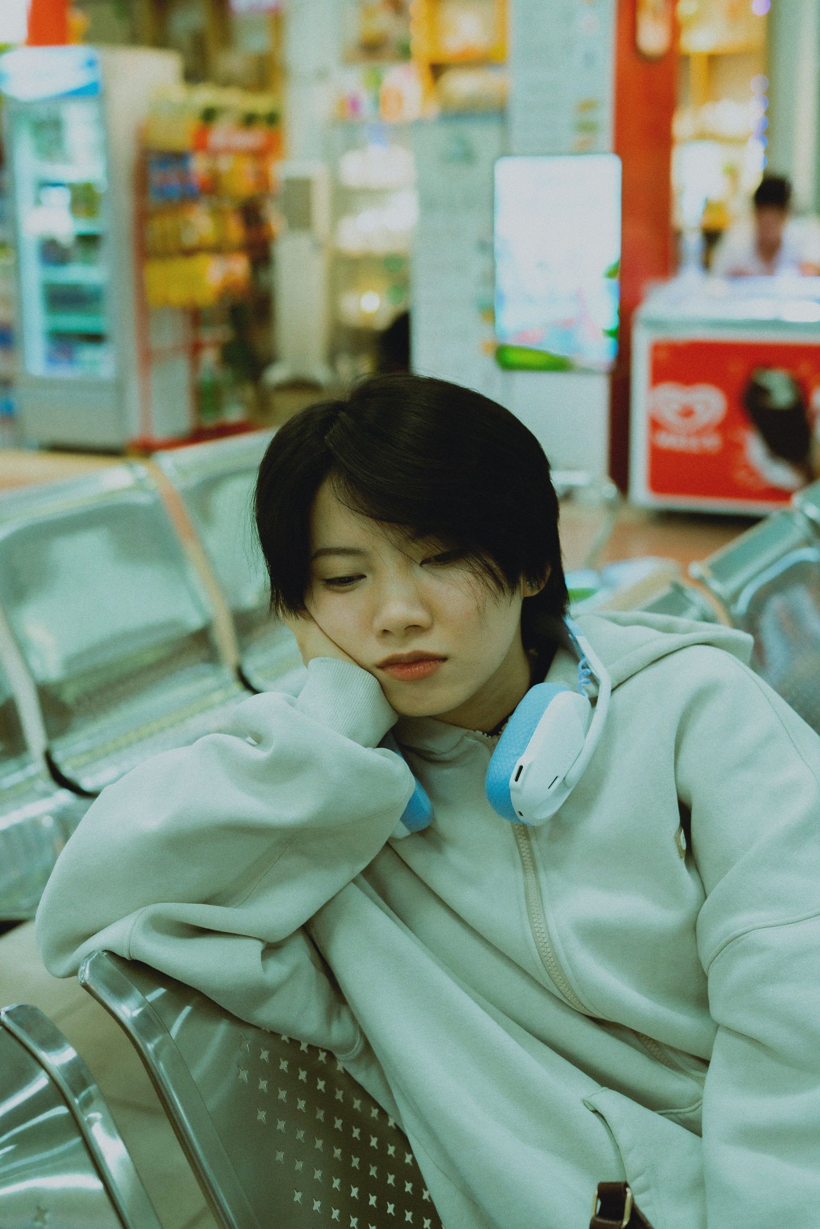 A young woman resting in an airport lounge, showing travel fatigue