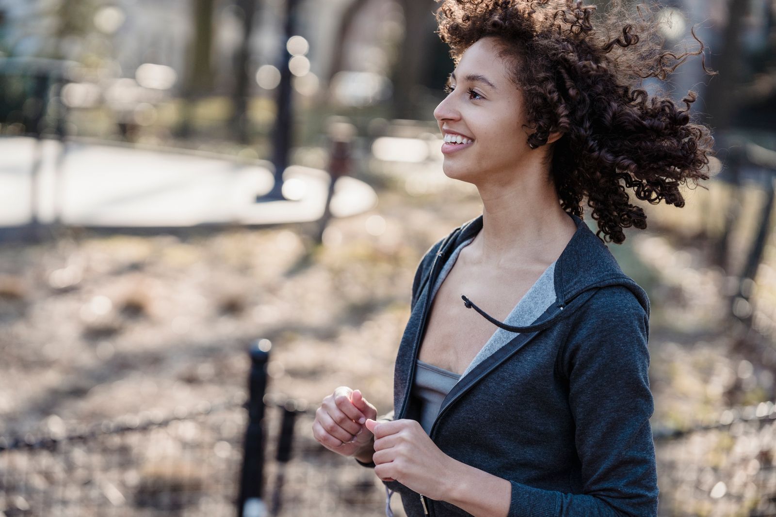 A woman smiling while running in a park