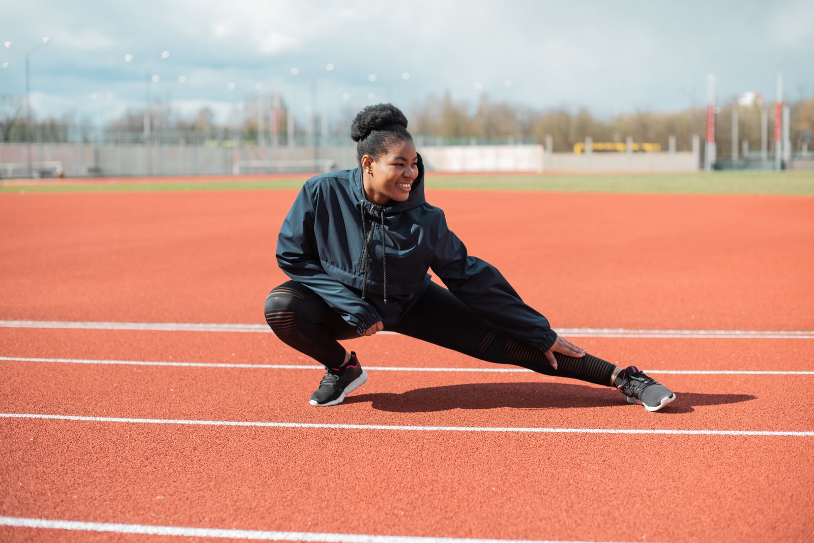 A woman stretching on a running track before a workout