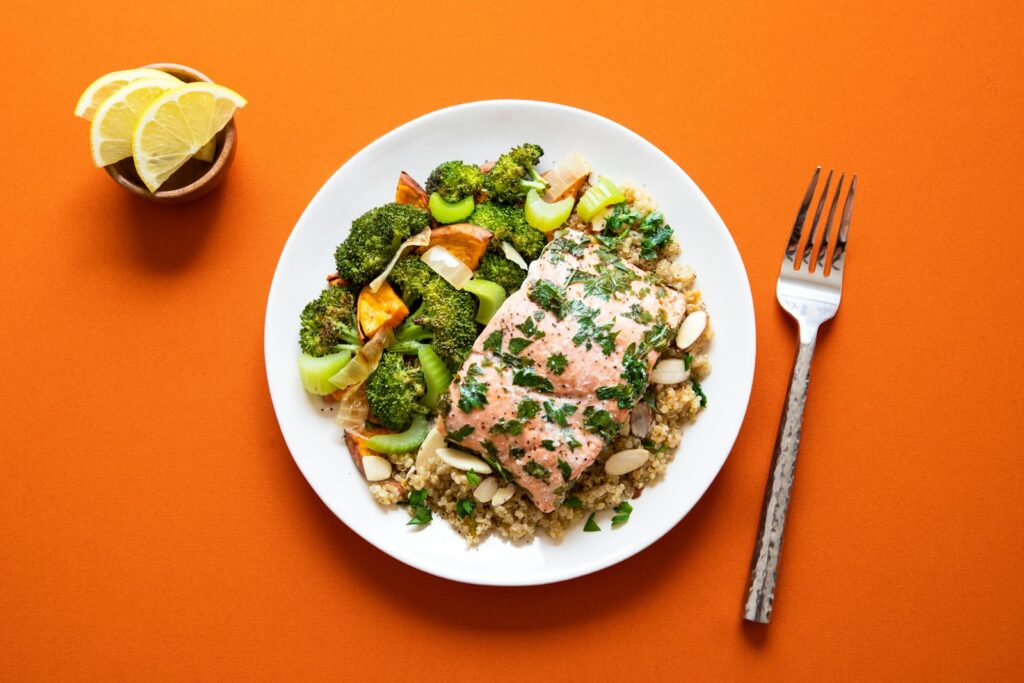 A balanced, portioned meal plate with salmon, quinoa, and roasted vegetables