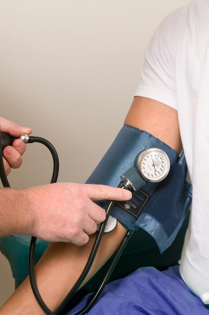 A doctor checking a patient blood pressure with a cuff